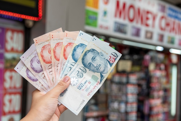 De dollarbankbiljetten van Singapore van de handholding, muntuitwisselingsconcept