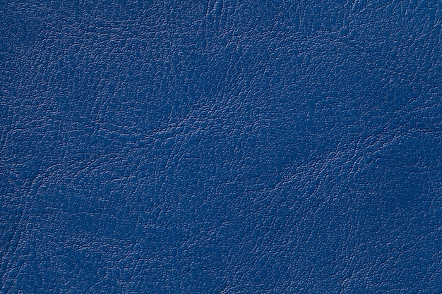 De donkere marineblauwe achtergrond van de leertextuur, close-up. denim kraakte de achtergrond van de rimpelhuid