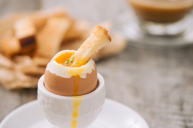 De dooier vloeit voort uit gekookt ei op toast