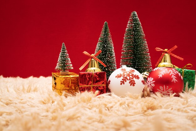 De doos en de boom van de Kerstmisgift met gouden klokken, denneappels op rode achtergrond