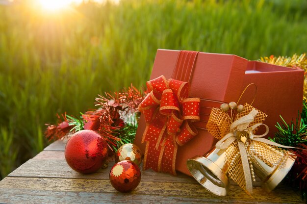 De doos van de Kerstmisgift met decoratie op houten lijst in zonsondergang