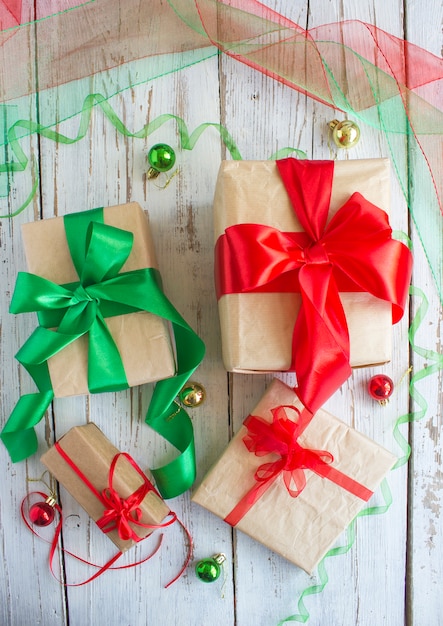 De doos van de Kerstmisgift met rood lint en nette tak op het wit over denneappels