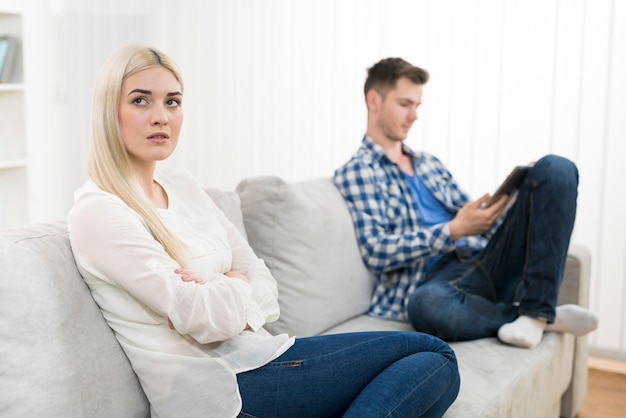 De droevige vrouw zit dichtbij droevige vrouw op de sofa