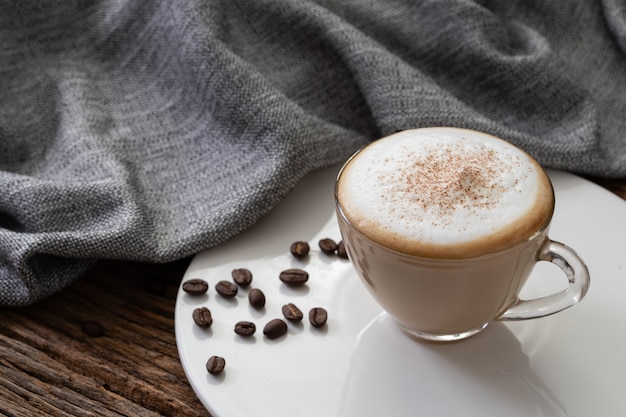 De duidelijke kop van de cappuccinokoffie op houten achtergrond voor de koffiemenu van de koffiekoffie