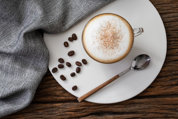 De duidelijke kop van de cappuccinokoffie op houten achtergrond voor de koffiemenu van de koffiekoffie