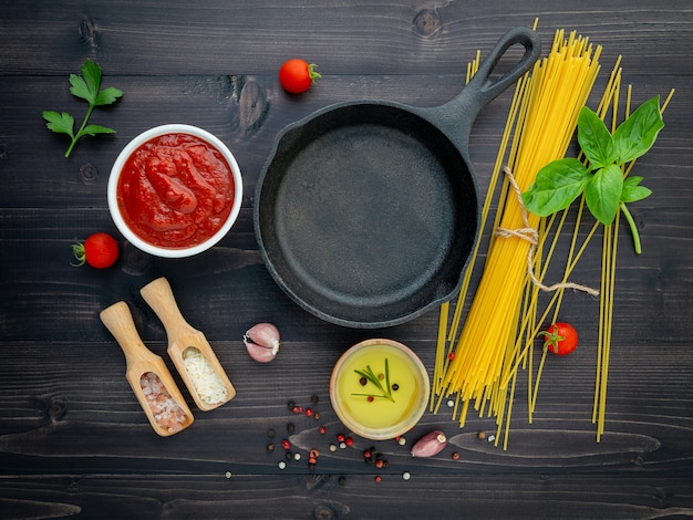 De dunne spaghetti op zwarte houten achtergrond.