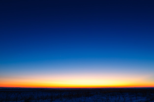 De eerste sterren op de achtergrond van een heldere zonsondergang.