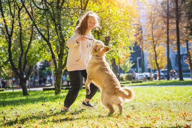 De eigenaar speelt de golden retriever-hond in het park