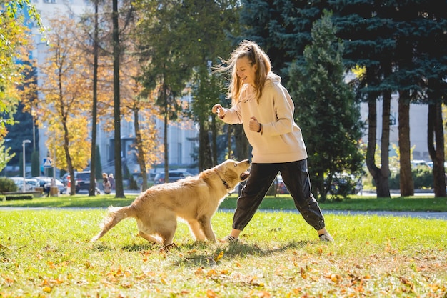 De eigenaar speelt de golden retriever-hond in het park