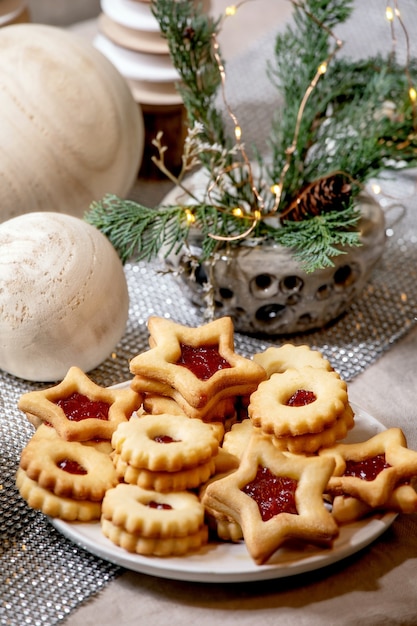 De eigengemaakte traditionele koekjes van de zandkoekkoekjes van Kerstmislinz met rode jam op plaat