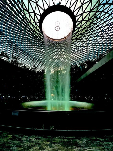 Foto de elegantie van de natuur in de architectuur een serene waterval oase genesteld tussen glas en groen