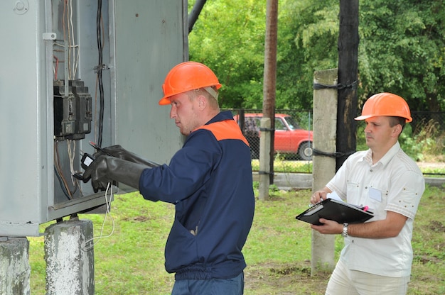 De elektrotechnisch ingenieur regelt de spanning op de schakelaars in de elektrische schakelkast.