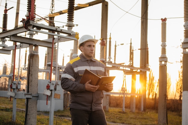 De energie-ingenieur inspecteert de apparatuur van het onderstation. Energietechniek. Industrie