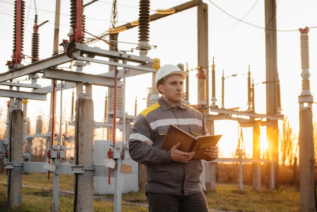 De energie-ingenieur inspecteert de apparatuur van het onderstation. Energietechniek. Industrie.