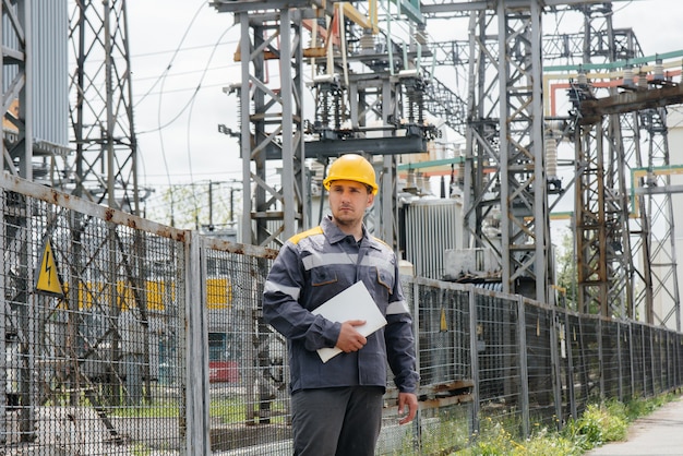 De energie-ingenieur inspecteert de apparatuur van het onderstation. Energietechniek. Industrie.