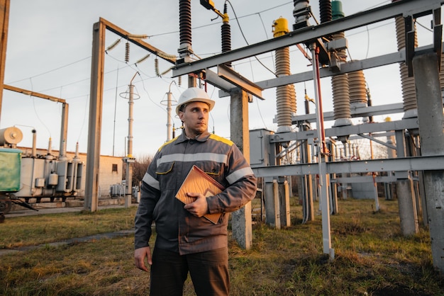 De energie-ingenieur inspecteert de apparatuur van het onderstation. Energietechniek. Industrie