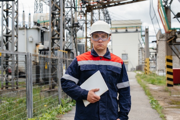 De energie-ingenieur inspecteert de uitrusting van het onderstation. Energietechniek. Industrie.