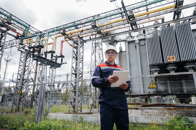 De energie-ingenieur inspecteert de uitrusting van het onderstation. Energietechniek. Industrie.