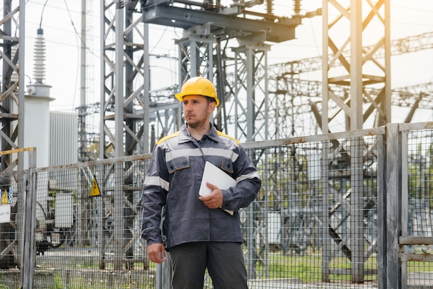 De energie-ingenieur inspecteert de uitrusting van het onderstation. Energietechniek. Industrie.