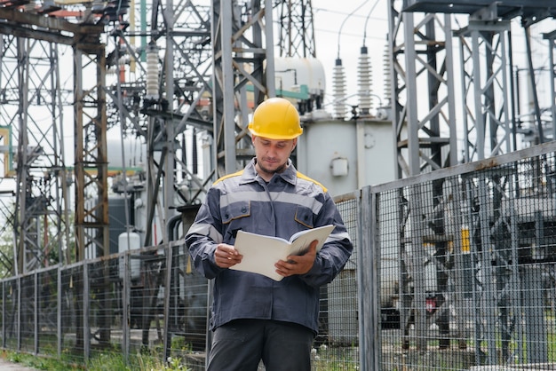 De energie-ingenieur inspecteert de uitrusting van het onderstation. Energietechniek. Industrie.