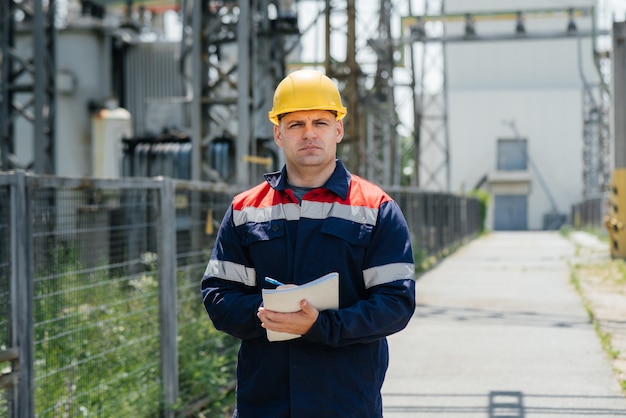 De energie-ingenieur inspecteert de uitrusting van het onderstation. energietechniek. industrie.