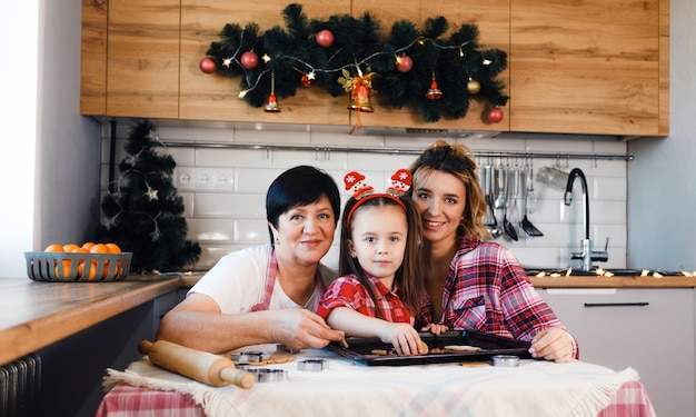 De familie in de keuken bereidt zich voor op Kerstmis en heeft plezier met het bakken van koekjes.