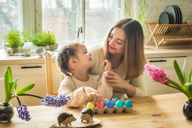 De familie schildert kleurrijke paaseieren moeder en dochter vieren samen de lentevakantie