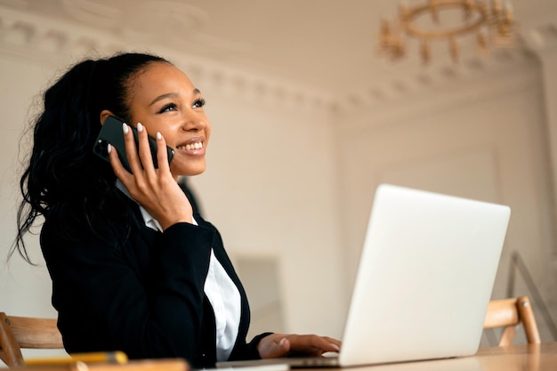 De financier belt een projectcollega aan de telefoon Zakenvrouw afro glimlacht manager aan het werk