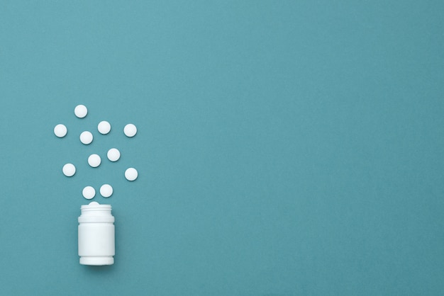 De foto van witte tabletten en drugs op een blauwe achtergrond