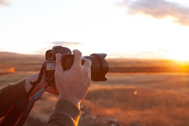 De fotograaf fotografeert de zonsondergang op de bergen