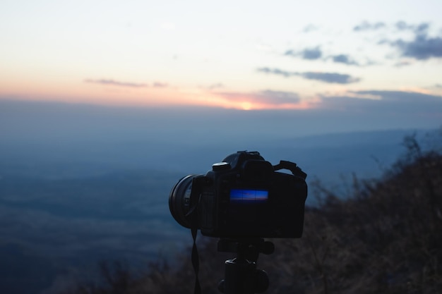 De fotograaf fotografeert de zonsondergang op de bergen