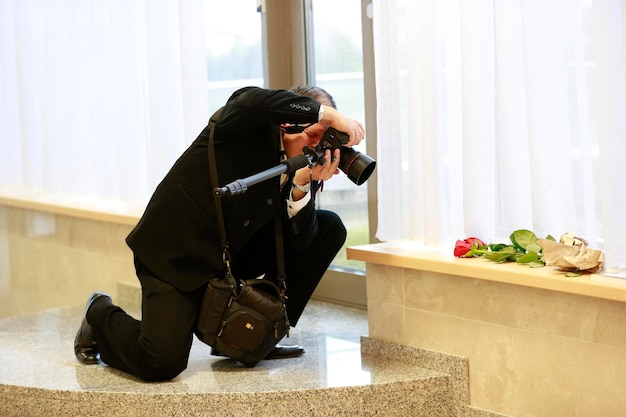 De fotograaf maakt een foto Een man met een camera fotografeert een bloem