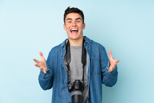 De fotograafmens van de tiener op blauwe muur ongelukkig en gefrustreerd met iets