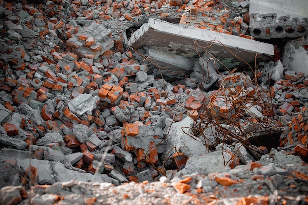 De fundering van een verwoest gebouw met fragmenten van rode bakstenen en vloeren van gewapend beton