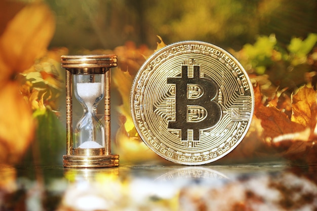 De fysieke bitcoin en zandloper laten zien dat de tijd komt en de herfst is aangebroken