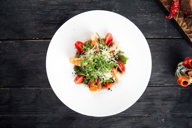 De gastronomische salade van arugulagarnalen in een witte plaat