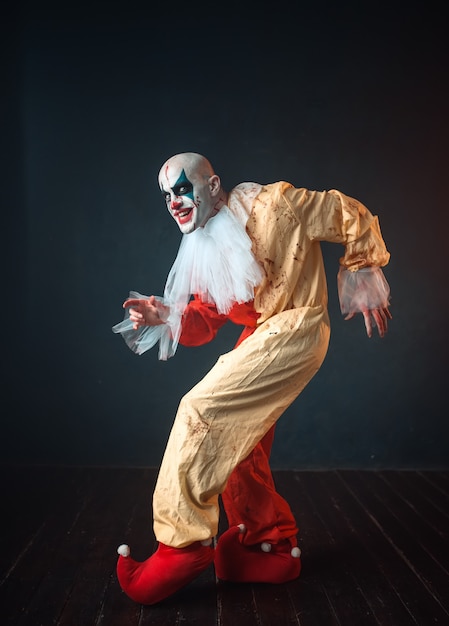 De gekke bloedige clown sluipt en toont het stille teken