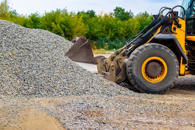 De gele bulldozer van de wiellader werkt in steengroeve