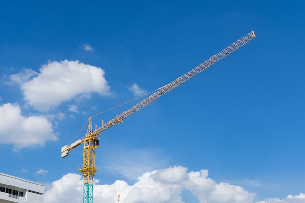 De gele kraan van de bouwtoren tegen blauwe hemel