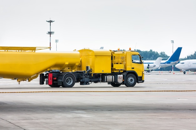 De gele tanker van tankwagenvliegtuigen bij het luchthavenschort