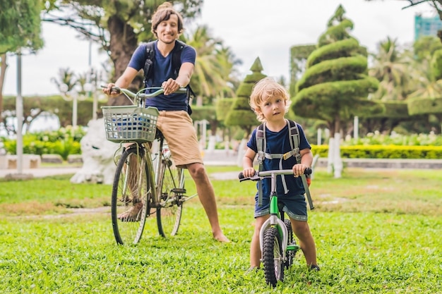 De gelukkige familie berijdt fietsen in openlucht en glimlachende vader