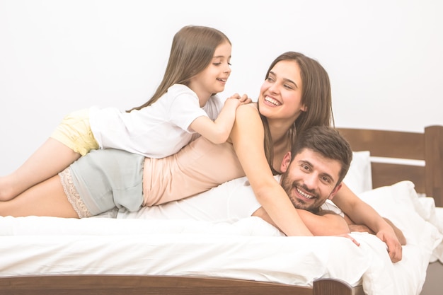 De gelukkige familie lag op het comfortabele bed