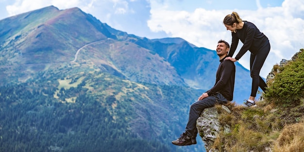 De gelukkige man en een vrouw genieten op de prachtige klif