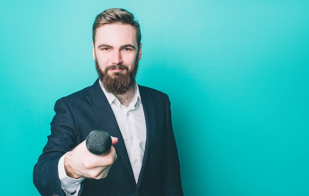 De gelukkige mens bevindt zich en kijkt ongecompliceerd. Hij houdt een microfoon vast voor een gesprek. Guy ziet er zelfverzekerd uit.