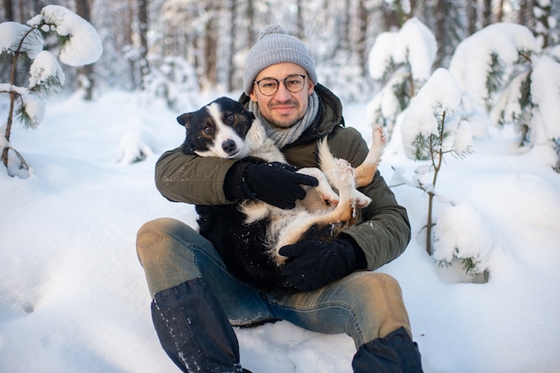 De gelukkige mens die mooie hond in van hem houden dient sneeuwbos in.