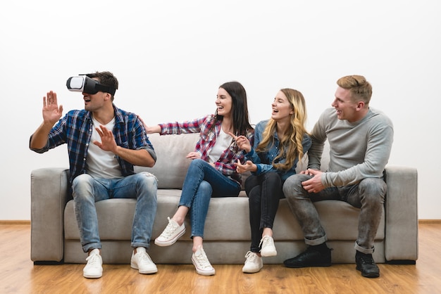 De gelukkige vrienden plezier met een virtual reality-bril op de witte achtergrond