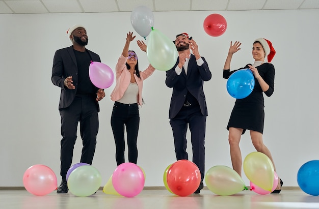 De gelukkige zakenmensen die met ballonnen spelen