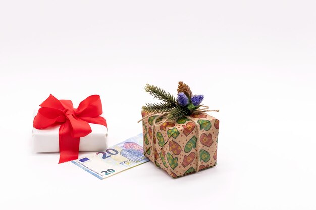 De geschenkdozen zijn versierd met een dennentak en een rood lint en een papieren biljet van 20 euro