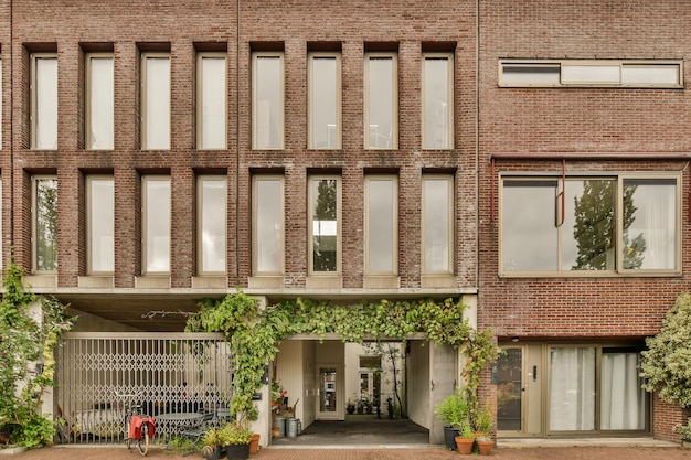 De gevel van een bakstenen gebouw met ramen en planten