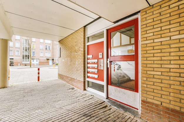 Foto de gevel van een bakstenen gebouw met rode deur met versieringen